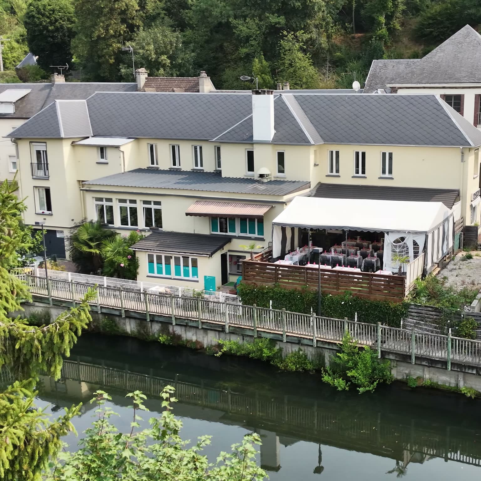 Le Risle vu depuis la rive opposée, avec sa terrasse au bord de l'eau